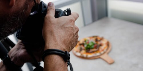 A food photographer is shooting pizza