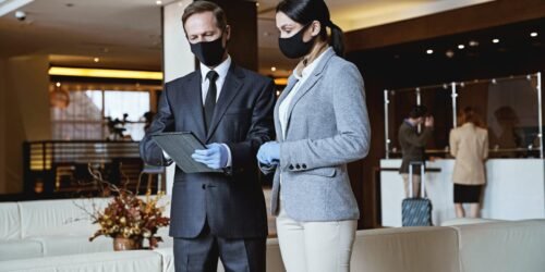 two-receptionists-looking-at-the-list-of-guests-in-their-gadget-scaled-1.jpg